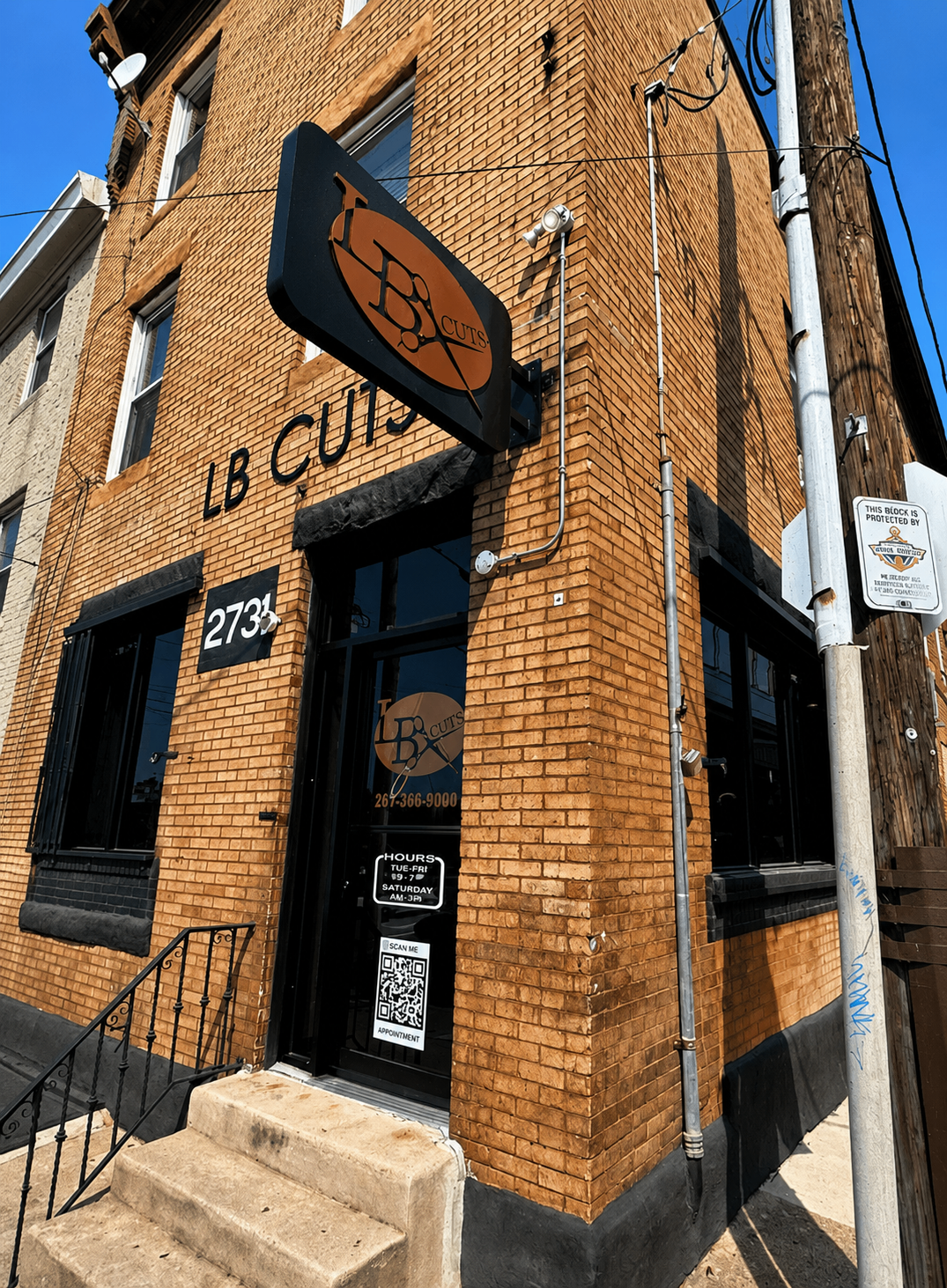LB Cuts storefront at 2735 — brick building with logo sign on a sunny Philadelphia street.